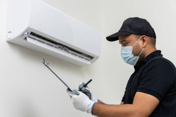 istock Air conditioner service indoors. Asian technician checking list and fix the Air conditioner. Air conditioner cleaning technician Clear the blocked air filter. He in uniform wearing rubber and mask. 1316732979