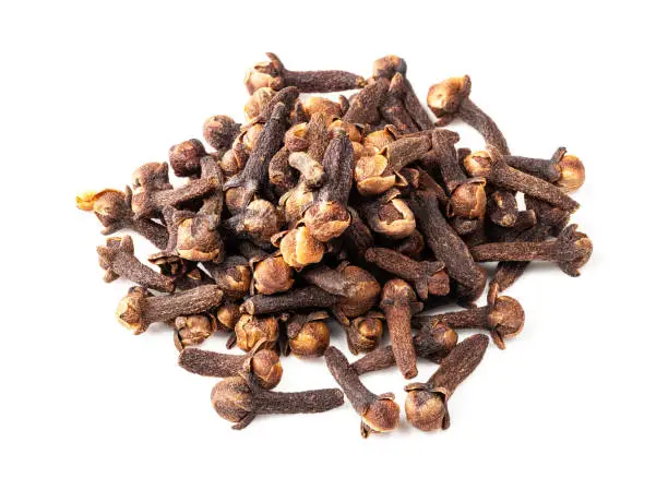 handful of dried cloves closeup on white background