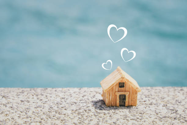 istock miniature house and  heart shape on concrete floor with blurred blue background, copy space, home sweet home , valentine, happy family concept 1316735028