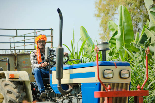 istock indian farmer with tractor at field 1316735041