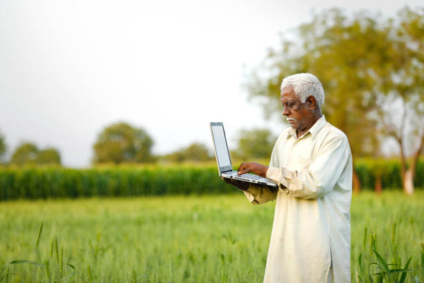 istock young indian farmer using laptop at wheat field 1316736043