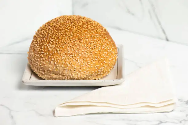 Freshly baked wholemeal bread roll with sesame seeds