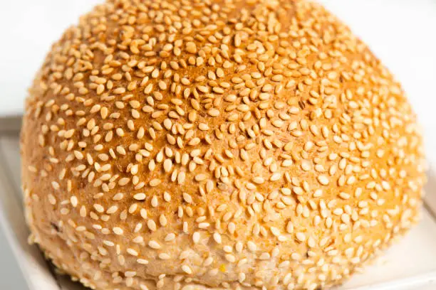 Freshly baked wholemeal bread roll with sesame seeds