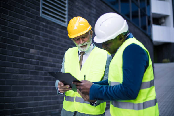 istock Two business architects on street reading document. 1316739236