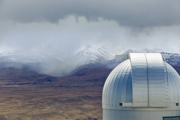 This October 24, 2019 photo shows a brief moment of sunlight shining on a dome at the Mt John Observatory in Tekapo, Aotearoa New Zealand. Snow is seen falling on the mountains in the distance. The research observatory is operated by the University of Canterbury.