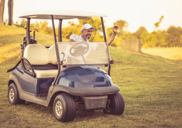 istock Happy Senior man driving golf car and waving. 1316741799