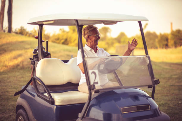 istock Senior woman driving golf car. 1316741802