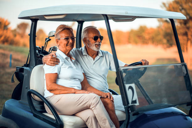 istock An elderly golf couple rides in a golf cart. 1316741847