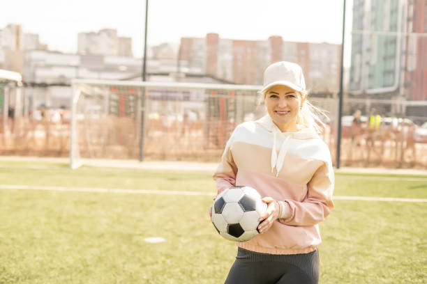 futebol feminino bonito. jovem em roupas esportivas com uma bola de futebol na grama - office business soccer exercising - fotografias e filmes do acervo