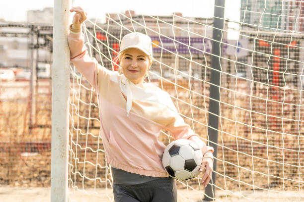 futebol feminino bonito. jovem em roupas esportivas com uma bola de futebol na grama - office business soccer exercising - fotografias e filmes do acervo