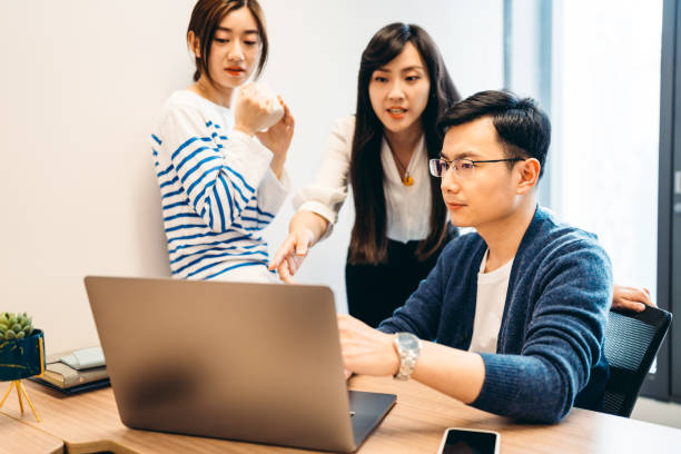 istock Asian young business people in discussion at modern office. 1316743859