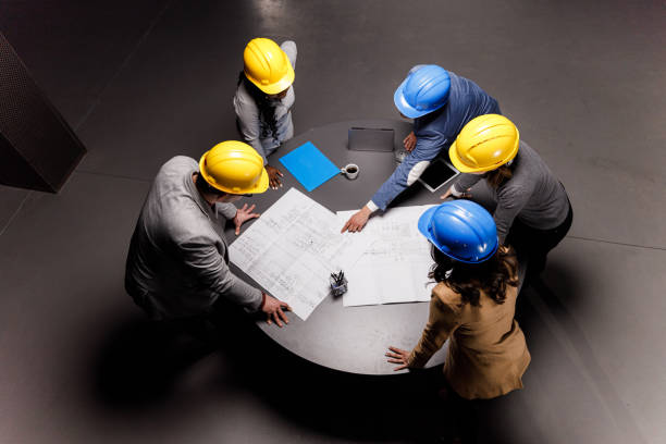 istock Above view of team of architects analyzing blueprints in the office. 1316746263