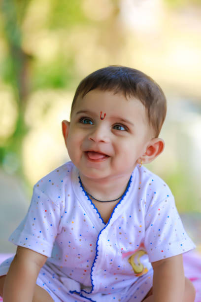 Cheerful child of Indian ethnicity staining portrait at home.