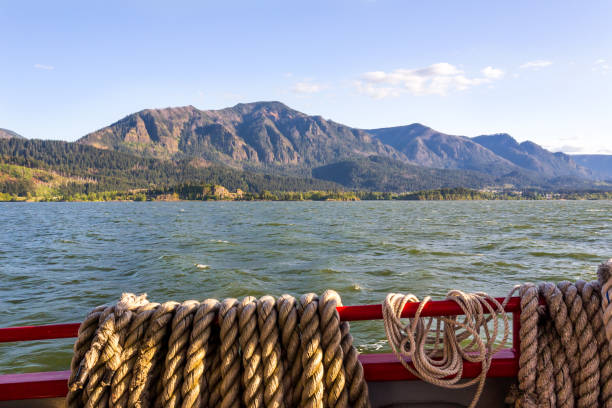 Beautiful view at riverbanks from the ship. Ship ropes in the foreground. Columbia river gorge, Oregon