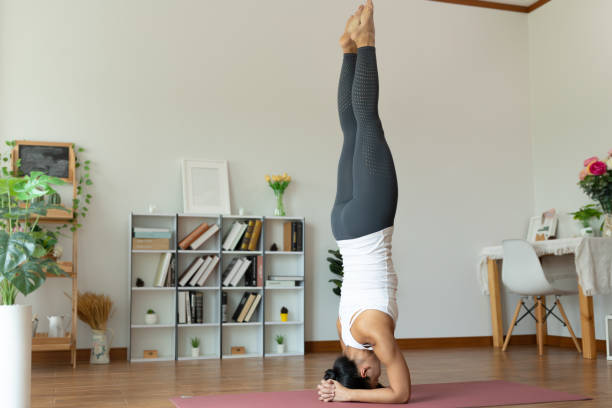 istock Asian woman practicing hand stand yoga in home. 1316756070