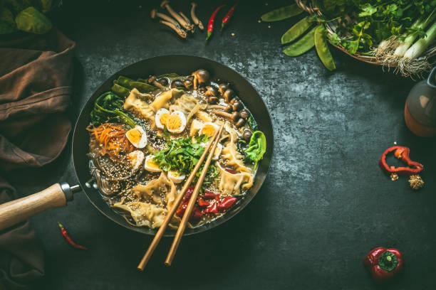 istock Wok pan with vegetarian  korean hot pot and chopsticks on dark rustic kitchen table background, top view. Copy space 1316757331