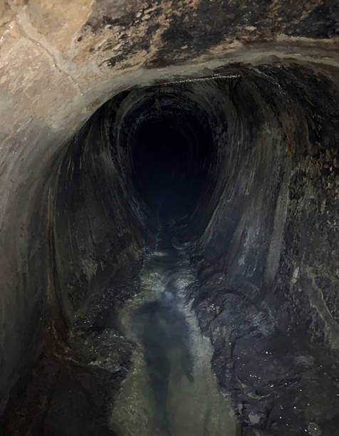 istock Round hole in the underground drenage system. Hole in the labyrinth 1316759825