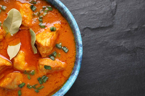 istock Bowl of delicious chicken curry on black table, top view. Space for text 1316760097