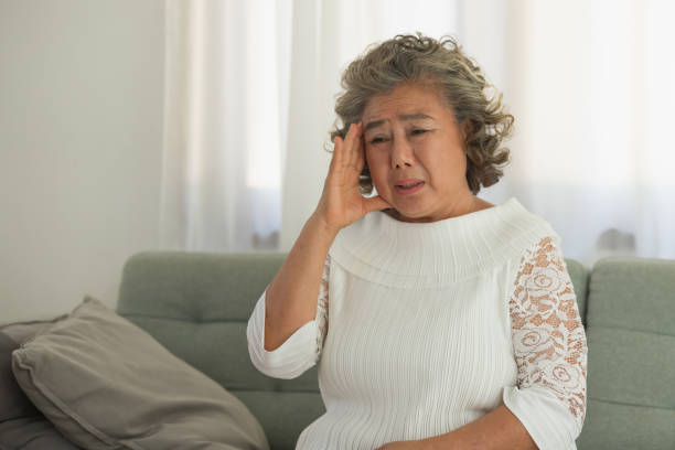 istock Asian Elderly man with a headache sitting on a bed in morning 1316760112