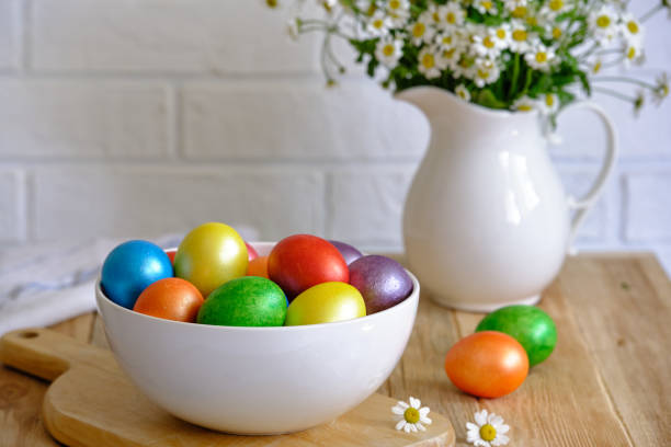 istock Colored Easter eggs with wild chamomy on old wood table on brick wall background 1316764886