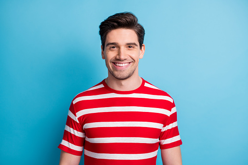 Photo of cute charming sweet man wear red outfit smiling isolated blue color background.