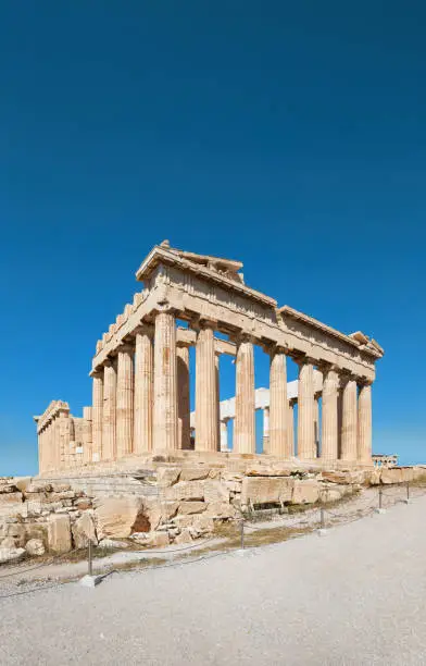 Parthenon temple on a bright day with blue sky. Panoramic image taken in Acropolis hill in Athens, Greece. Classical ancient Greek civilization landmark, famous place, vertical panoramic travel background.