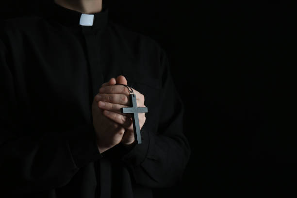 istock Priest with cross on dark background, closeup. Space for text 1316769037