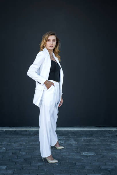 istock modern pretty woman in white suit isolated on black background 1316770509