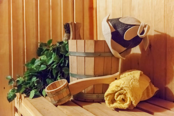 detalhes interiores casa de banho de sauna finlandesa com acessórios tradicionais de sauna bacia de vassoura de vassoura toalha de chapéu de feltro - massaging relaxation indoors traditional culture - fotografias e filmes do acervo