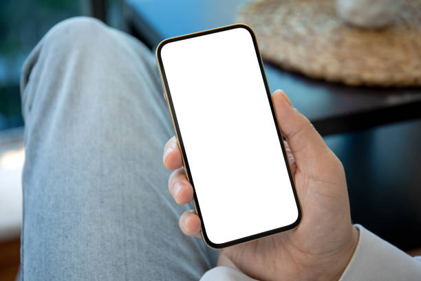 istock man in jeans holding gold phone with isolated screen 1316773083