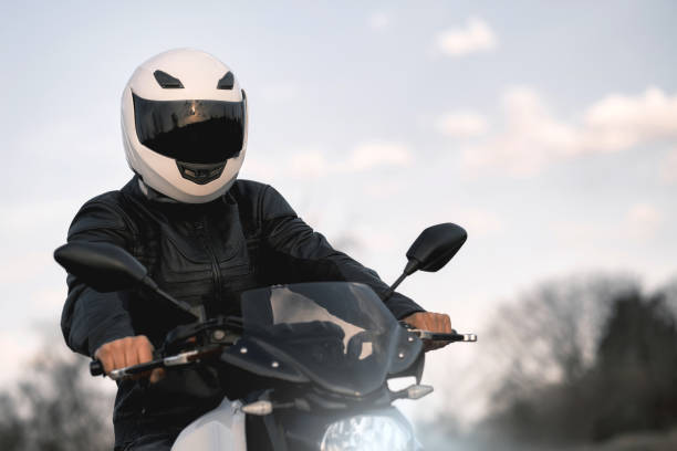 portret młodego mężczyzny siedzącego na motocyklu i ubranego w skórzaną kurtkę i kask. - motorcycle mirror biker glove zdjęcia i obrazy z banku zdjęć