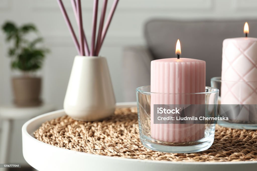 Burning candles and air reed freshener on table indoors, space for text Candle Stock Photo