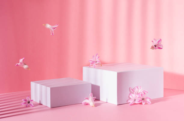 istock White square podiums for display cosmetic, products in sunlight with spring flowers flying and striped shadow in sunny day on pink background, copy space. 1316780528