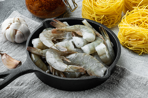 Pasta taglierini with pesto sauce and shrimps ingredients set, on gray stone background
