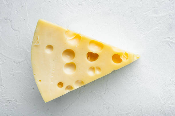 maasdam-käse, auf weißer steinoberfläche, ansicht von oben flach liegend - maasdam stock-fotos und bilder
