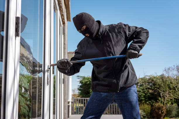 istock Burglar breaking into a house via a window with a crowbar 1316784250