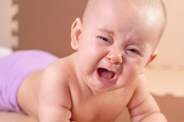 istock Crying baby lying on the floor after falling onto a foam mat 1316787325