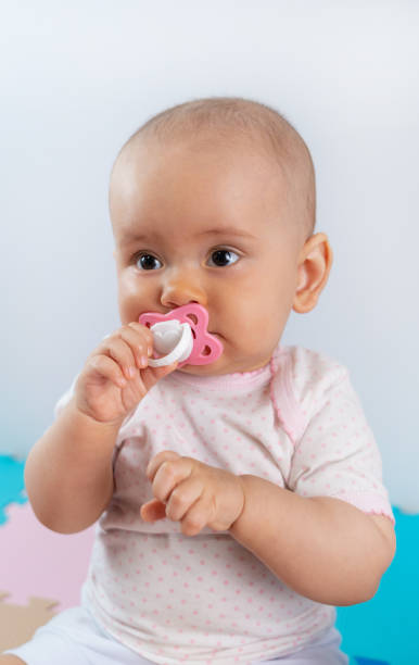 istock Newborn baby with pink pacifier in mouth 1316790002