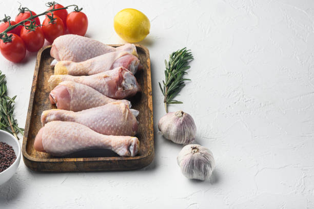 istock Chicken drumstick with spices and herbs, on white background, with copy space for text 1316790308