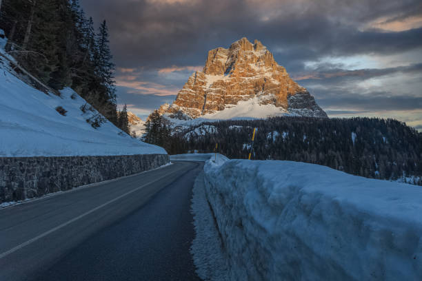 Winter panorama on Mount Pelmo at sunset with a snow-bordered road