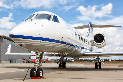 Modern private blue airplane landing at Miami International Airport.