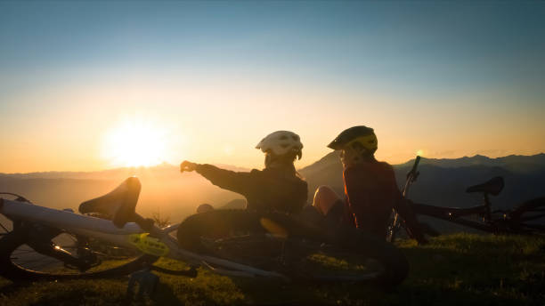 istock Girls with mountain bikes sitting on mountain at sunset 1316795169