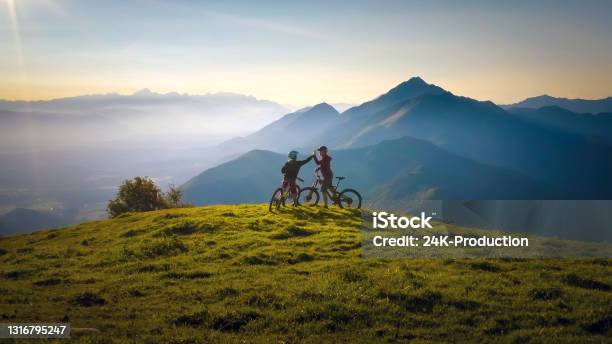 Woman High Five Over The Sunset At Mountain Biking Trip Stock Photo - Download Image Now