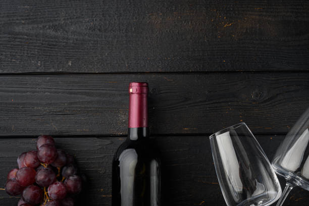 istock Red wine and grapes, on black wooden table background, top view flat lay, with copy space for text 1316796135