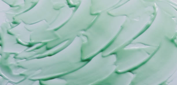 istock Chaotically smeared green body cream on white background 1316796322