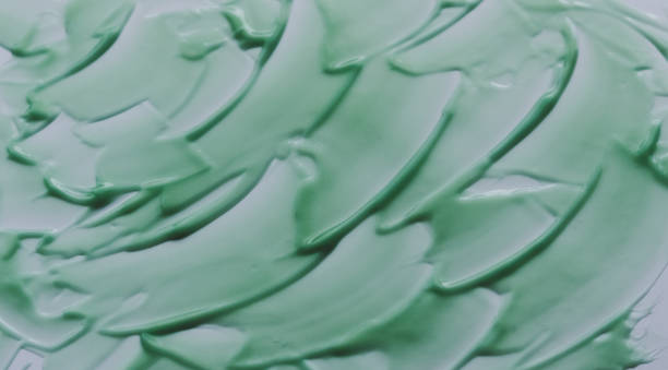 istock Chaotically smeared green body cream on white background 1316796358