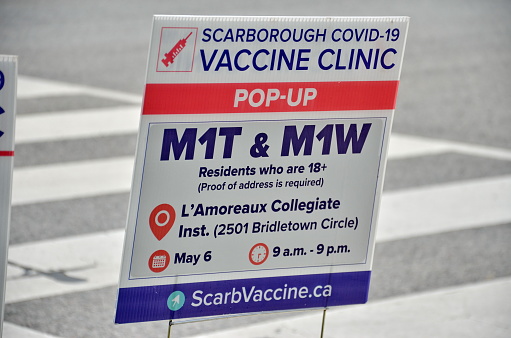 Scarborough, Ontario, Canada, May 6, 2021: People wait in line for a Covid-19 vaccine at the pop-up vaccine clinic at L'Amoreaux Collegiate, 2501 Bridletown Circle in Scarborough, Ontario, Canada.