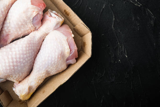 istock Raw fresh chicken thight or leg, in paper Pack, on black stone background, top view flat lay, with copy space for text 1316798175