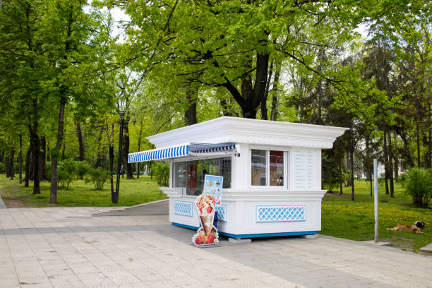 Ice cream shop boutique exterior Beautiful modern white ice cream shop in the park with no people around it. Shop without costumers, exterior view. Chisinau, Republic of Moldova - May 2021 chisinau photos stock pictures, royalty-free photos & images
