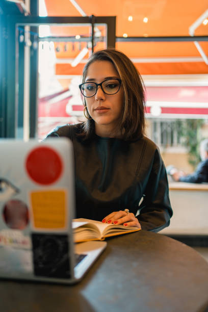 istock Young woman taking notes at a cafe 1316799736